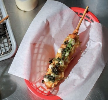 נקניקייה על מקל בציפוי פירה ונגיעות קוויאר